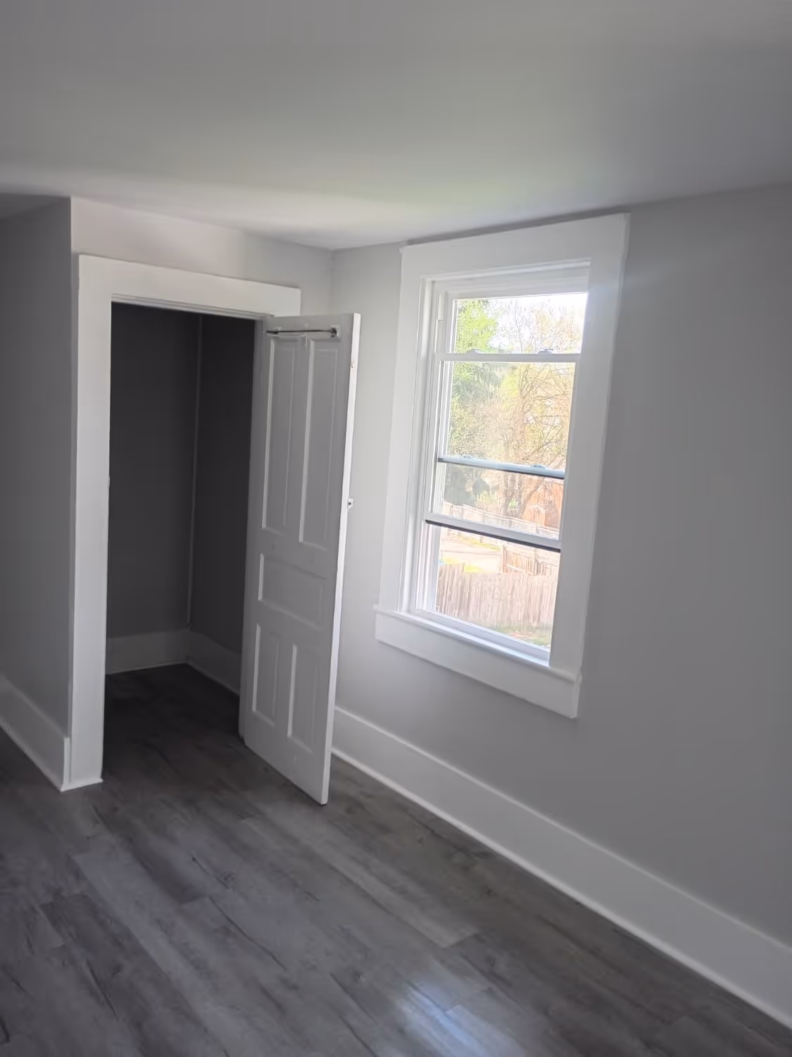 A finished bedroom at Margray, new window, fresh paint, and new plank flooring